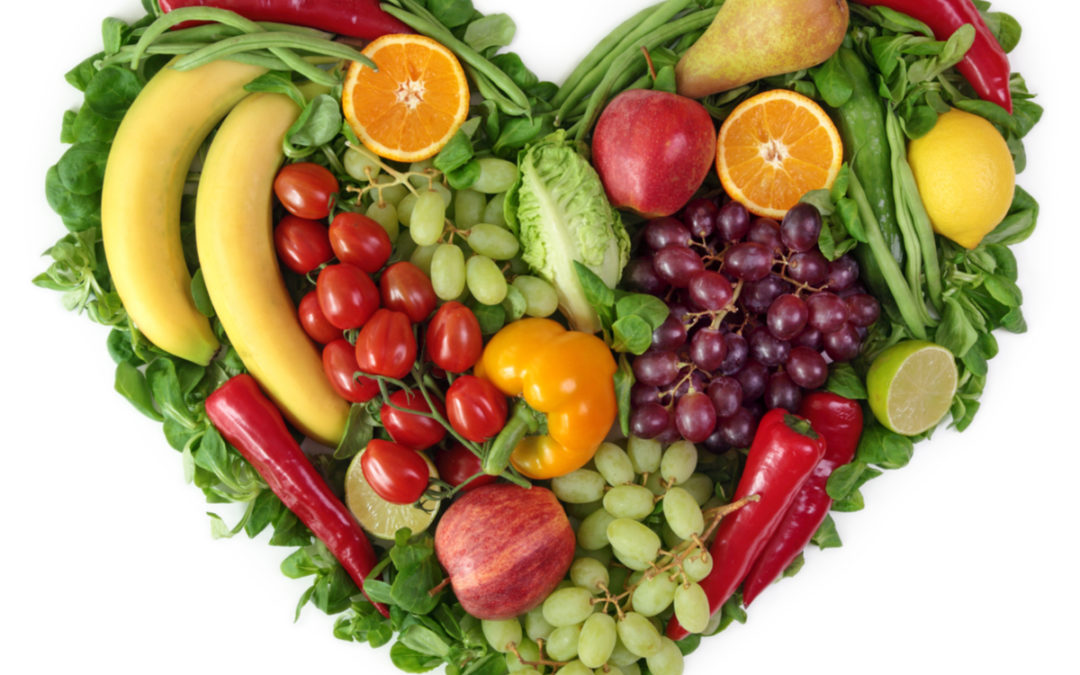 fruits and vegetables gathered together to form the shape of a heart