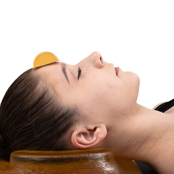 patient with a ophthalmic cradle headrest forehead protector on her forehead