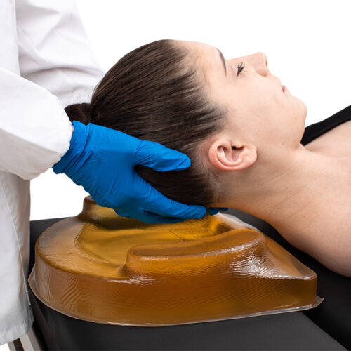 nurse placing a patient's head on an adult ophthalmic cradle headrest