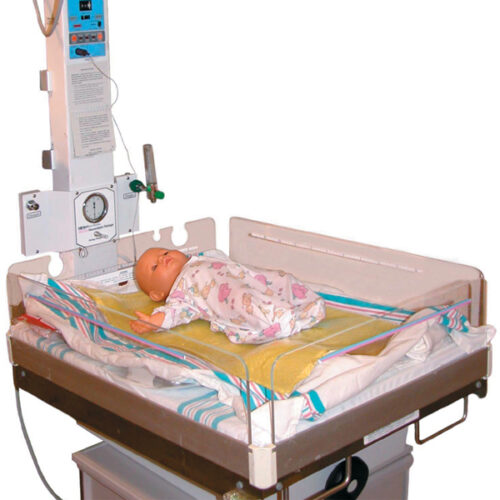 An Isolette Pad that is set up in a mock scenario with a baby doll